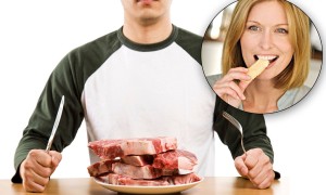 BRHC61 A hungry man holding a knife and a fork ready to eat a stack of raw steak